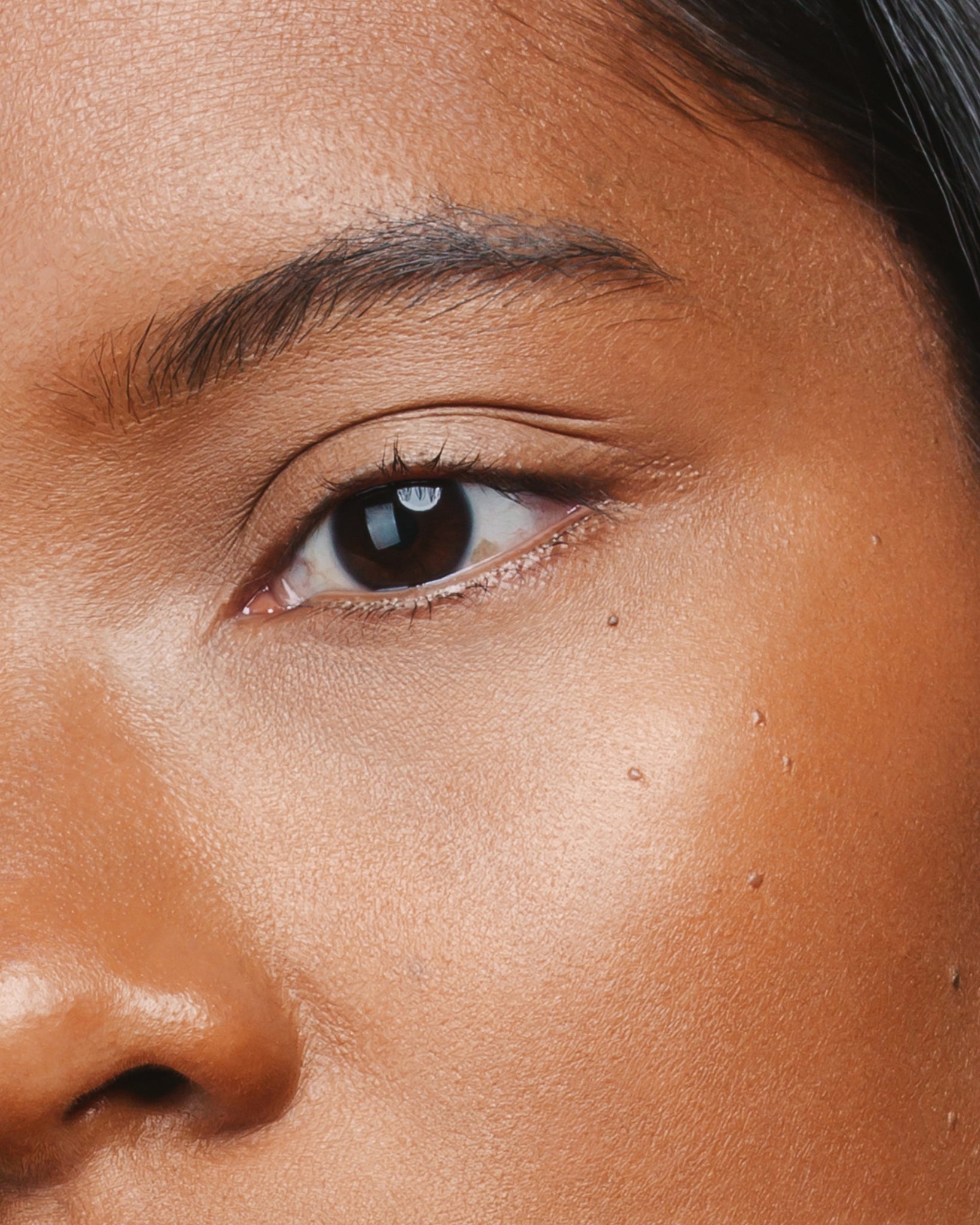 Model wearing MÁDARA Organic Skincare the concealer hazelnut on A6104 concealer on skin; close-up portrait shows natural application results.