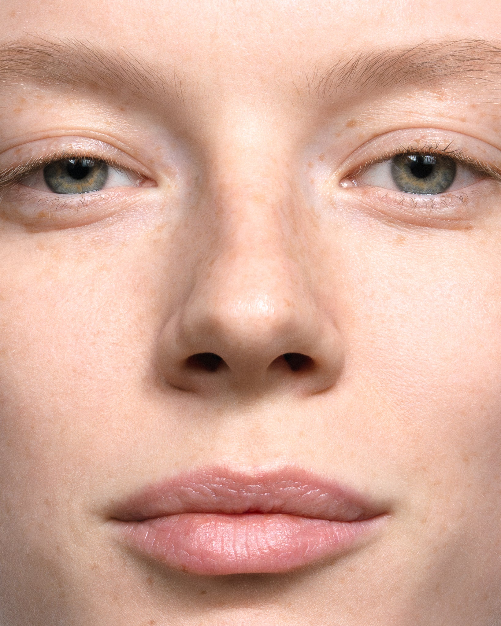 Model wearing MÁDARA Organic Skincare may flower serum on A3511 serum on skin; close-up portrait shows natural application results.