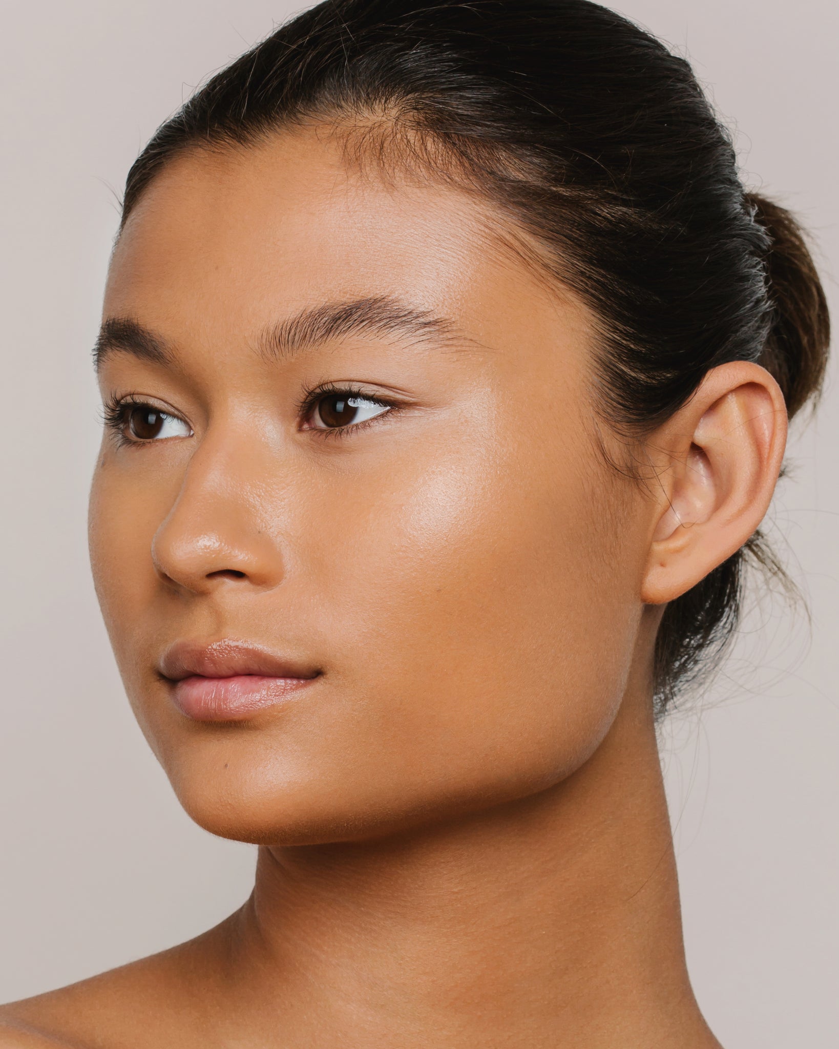 Model wearing MÁDARA Organic Skincare skin equal olive on A6061 on skin; close-up portrait shows natural application results.