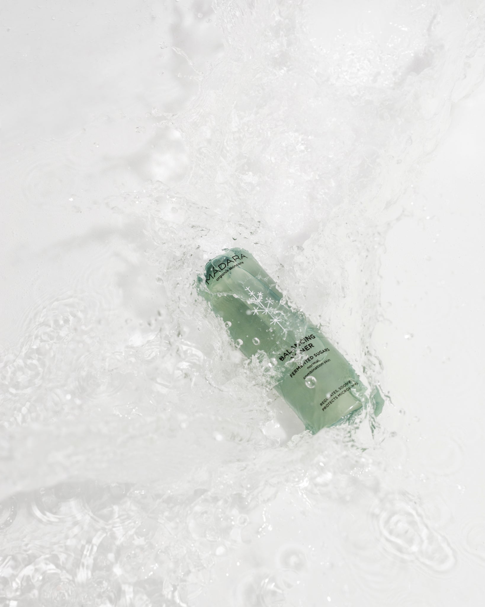 Model wearing MÁDARA Organic Skincare refreshing face toner A2052 toner on skin; close-up portrait shows natural application results.